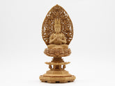 A statue of Dainichi Nyorai Buddha of the Shingon sect, made of camphor wood, surrounded by a halo of flying clouds, on an octagonal base.